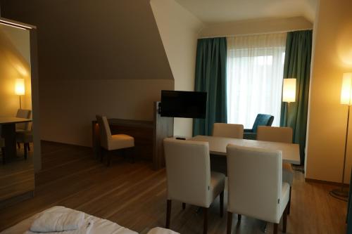 a hotel room with a table and chairs and a room at Meyn's Apartments & Hotel in Soltau