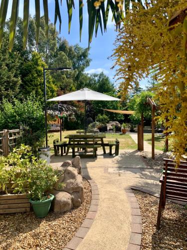 a park with picnic tables and an umbrella at Woodpaddock Bed & Breakfast in March