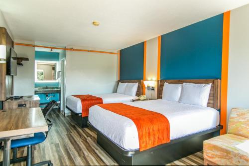 a hotel room with two beds and a couch at Jubilee Inn in Biloxi