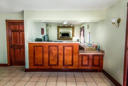 een keuken met een aanrecht met een wastafel en een spiegel bij Jubilee Inn in Biloxi