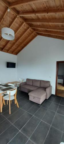 a living room with a couch and a table at Susete Village in São Roque do Pico