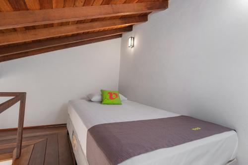a small bedroom with a bed and wooden floors at Pousada Golf Village in Itaipava