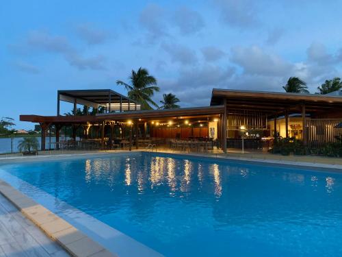un hôtel avec une piscine devant un bâtiment dans l'établissement Hotel Mercure Kourou Ariatel, à Kourou