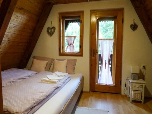 una camera con un letto e due finestre e una porta di Wooden Cottage a Jesenice