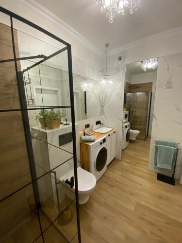 a bathroom with a washing machine and a toilet at Apartament rodzinny in Gdańsk