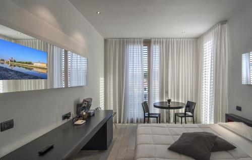 um quarto com uma cama e uma mesa com cadeiras em Blue Shades ApartHotel em Pisa