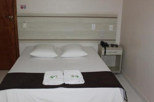 a bedroom with a bed with two towels on it at Hotel Galead in Santa Bárbara dʼOeste