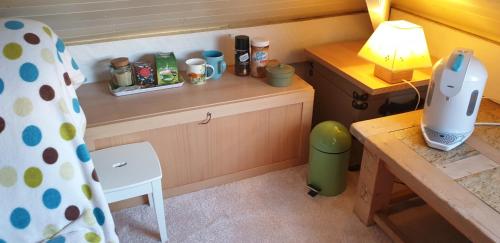 een kleine keuken met een bureau en een tafel met een lamp bij Le studio fridge tv microwave, in Chester