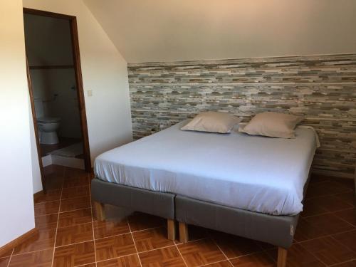 Casa das Flores في Monte Redondo: سرير في غرفة بجدار من الطوب