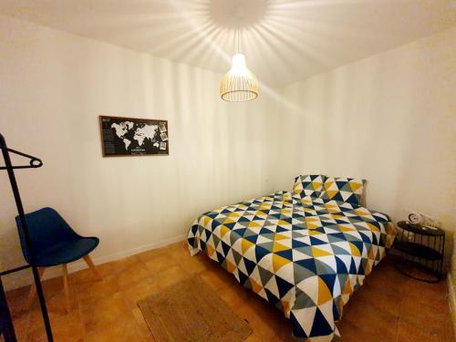 1 dormitorio con 1 cama y 1 silla azul en Superbe Appartement de 50m2, en Graulhet