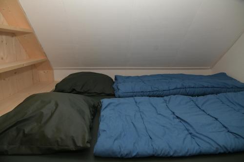 a bed with two pillows sitting in a room at Basic vakantiehuisje op val d'Or in Enscherange