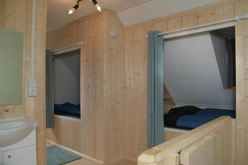 een houten hut met een wastafel en een bed erin bij Basic vakantiehuisje op val d'Or in Enscherange
