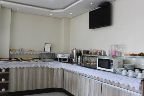 a kitchen with a counter with a microwave at Hotel Galead in Santa Bárbara dʼOeste