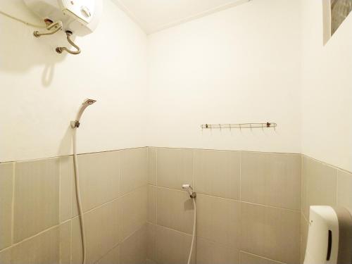 a bathroom with a shower with a shower head at Wisma Mulia Syariah Bandar Lampung in Hajimana