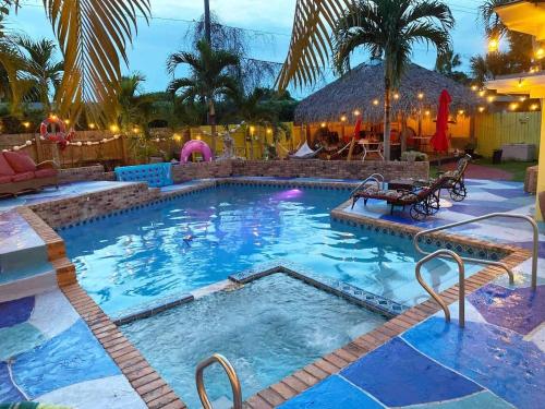 a pool at a resort at night with palm trees at Hidden Oasis in West Palm Beach