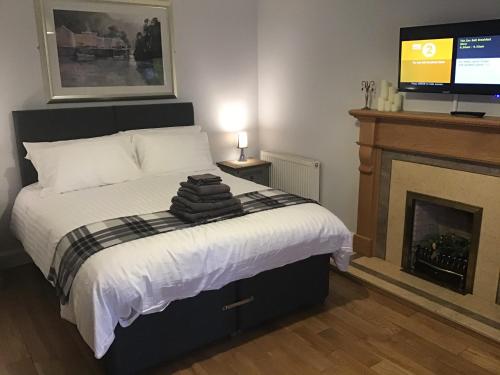 a bedroom with a bed with a fireplace and a television at Number One in Haddington