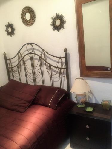 a bedroom with a bed and two mirrors on the wall at Residence Las Trojes Cdmx in Mexico City