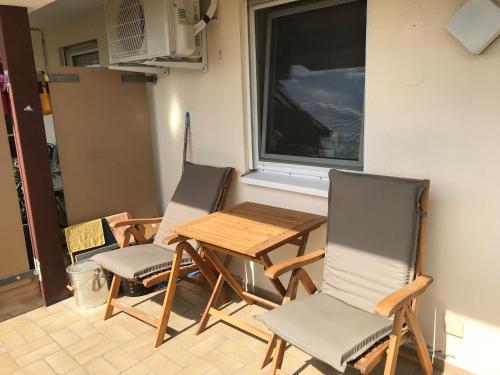 three chairs and a table in a room with a window at Loft Unterkunft in Hügelsheim in Hügelsheim