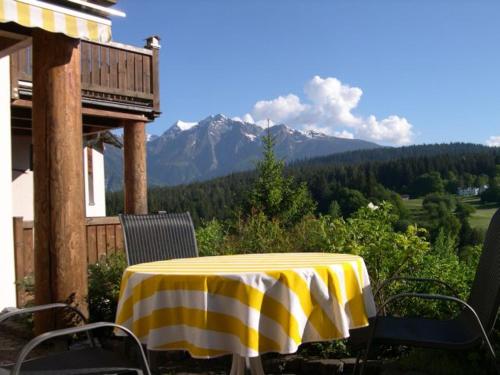 a yellow and white table and chairs on a porch with a mountain at Panorama A23 Fitzi - Ferienwohnung für 1-2 Personen in Flims