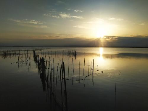 a large body of water with the sun in the sky at Hostal El Perelló, Valencia in El Perelló