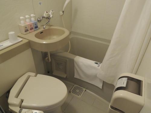 a small bathroom with a toilet and a sink at HOTEL LiVEMAX Kyoto Gojo in Kyoto