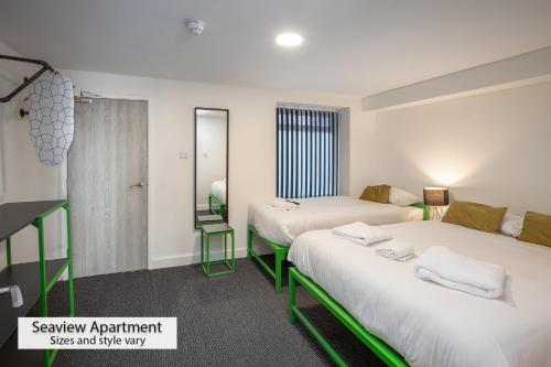 a room with two beds and a mirror at ApartHotel421 by Seafront Collection in Blackpool