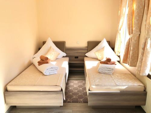 two beds in a small room with towels on them at Pension Goldenes Vogtland in Adorf