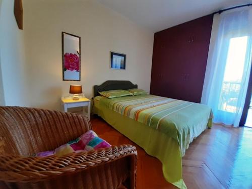 a bedroom with a bed and a chair in a room at Family apartment Garden and Sea in Petrovac na Moru