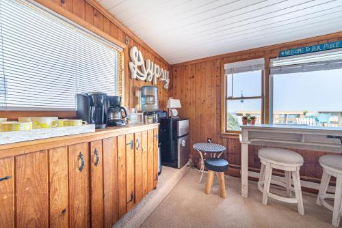 a kitchen with wooden cabinets and a bar with stools at Gypsea Rose in Southern Shores