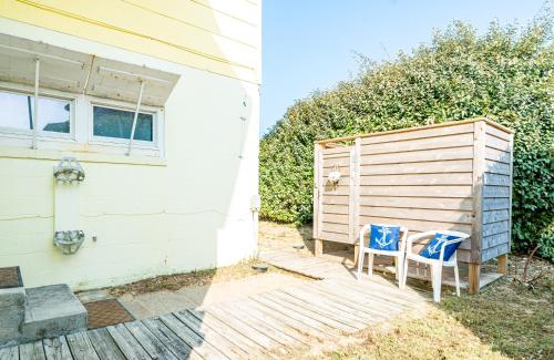 two chairs sitting on a deck next to a house at Gypsea Rose in Southern Shores