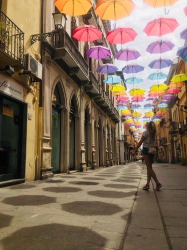 a woman walking down a street under a bunch of umbrellas at Bobo’s Home in Iglesias