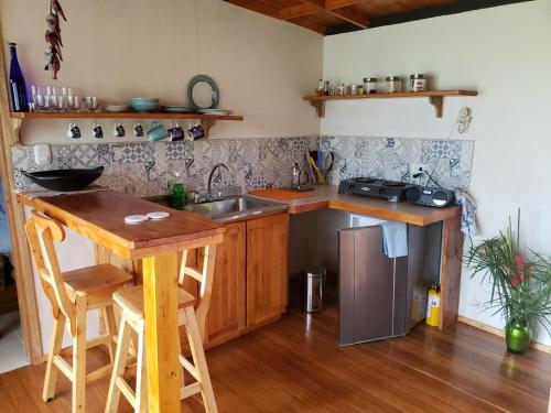 a kitchen with a sink and a wooden table at Cabaña Manalí in Guatapé