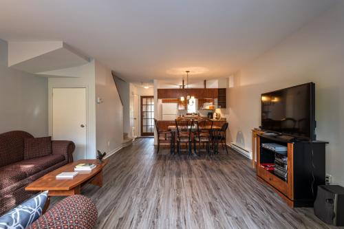 a living room with a couch and a table at Aiglon by Rendez-Vous Mont-Tremblant in Mont-Tremblant