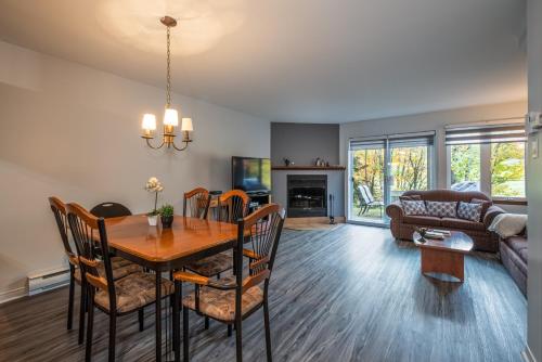 a dining room and living room with a table and chairs at Aiglon by Rendez-Vous Mont-Tremblant in Mont-Tremblant