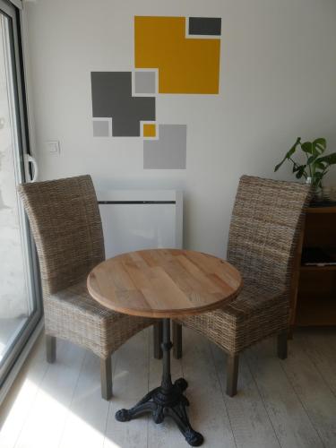 a wooden table and two chairs in a room at Opale des Caps in Leubringhen