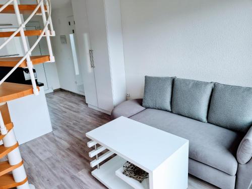 ein Wohnzimmer mit einem Sofa und einem weißen Tisch in der Unterkunft Apartmán 1+1 s vlastním vchodem v Jeseníkách in Vrbno pod Pradědem