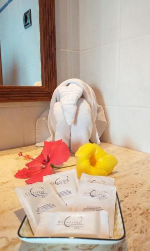 a tray with towels and flowers on a table at Aparthotel El Cerrito in Los Cancajos