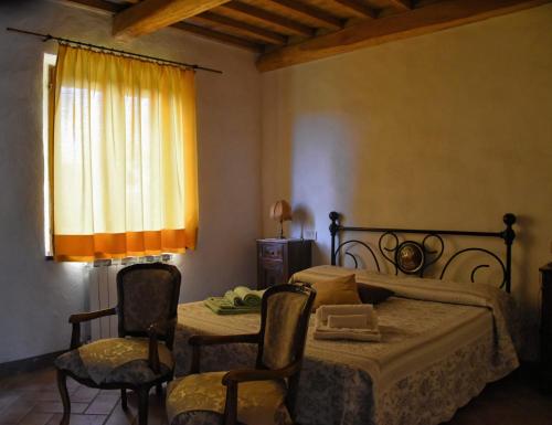 1 dormitorio con 1 cama, mesa y sillas en Casa Vacanze Porta Vecchia, en Montalcino