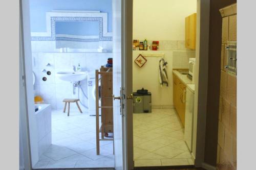 a kitchen with a door open to a kitchen with a sink at Laaser Gutshaus mit idyllischem Park- Malerwohnung in Laase