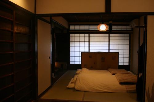a bed in a room with a window at Guesthouse KYOTO COMPASS in Kyoto