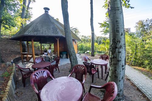 a group of tables and chairs in front of a gazebo at 4 Évszak Hegyihotel in Mátraháza