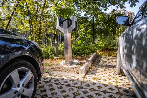 a car parked next to a cross on a road at 4 Évszak Hegyihotel in Mátraháza