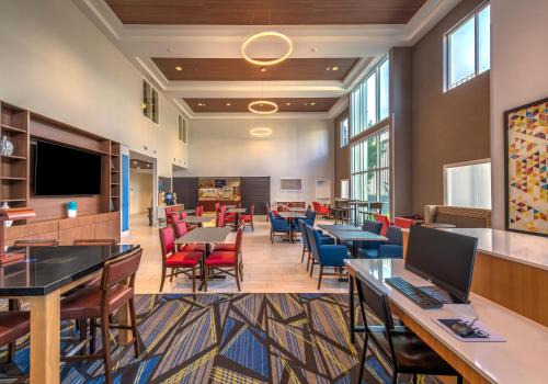 a lobby with tables and chairs and a cafeteria at Holiday Inn Express Reno Airport, an IHG Hotel in Reno