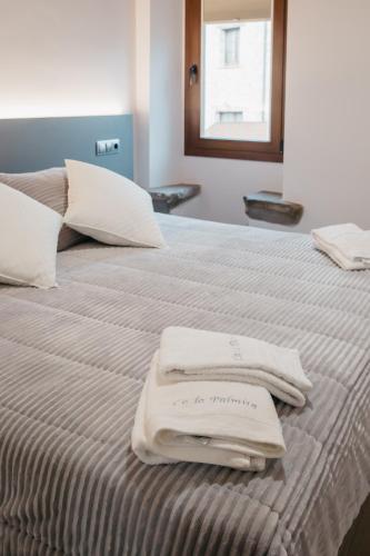 a bed with two towels sitting on top of it at Apartaments Rurals Cala Palmira in Alpens