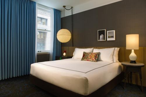 a bedroom with a large bed and a window at Kimpton Gray Hotel Chicago by IHG in Chicago