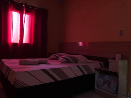 a bedroom with a bed with a red window at Hotel Popular Vila Mariana in Sao Paulo