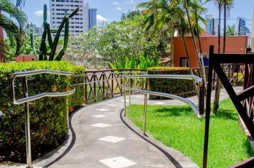 a walkway leading to a park filled with palm trees at Pousada Vale do Sul in Natal