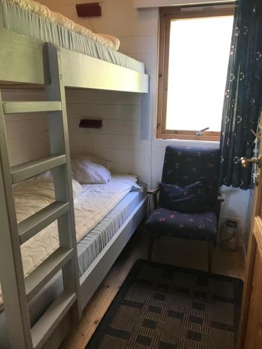 a bunk bed and a chair in a small room at Ferienhaus „Draumen“ in Norwegen in Bømlo