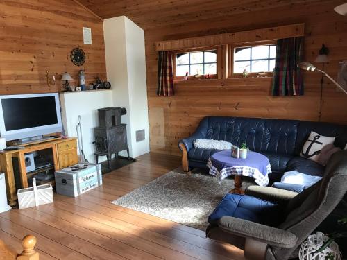 a living room with a couch and a tv at Ferienhaus „Draumen“ in Norwegen in Bømlo