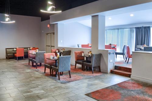 a restaurant with tables and chairs in a lobby at Holiday Inn Mobile West I-10 by IHG in Tillmans Corner